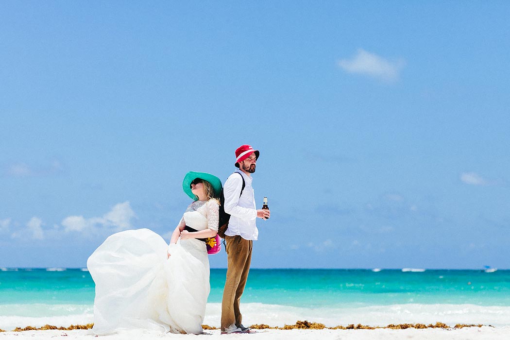 Wedding Photo in Tulum - Bride and Groom drinking bear - amazing blue turquoise ocean water